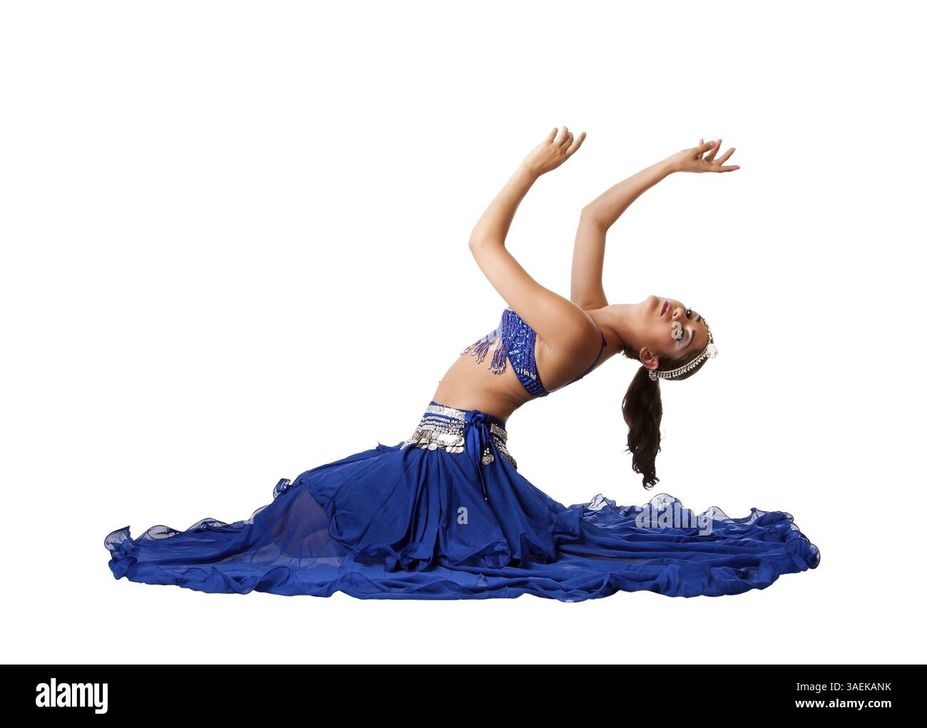 Belle égyptienne Israélien moyen-orientale danseuse du ventre libanaise performer en bleu jupe et soutien-gorge avec des bras dans l'air assis en arrière et de flexion, isolat Banque D'Images