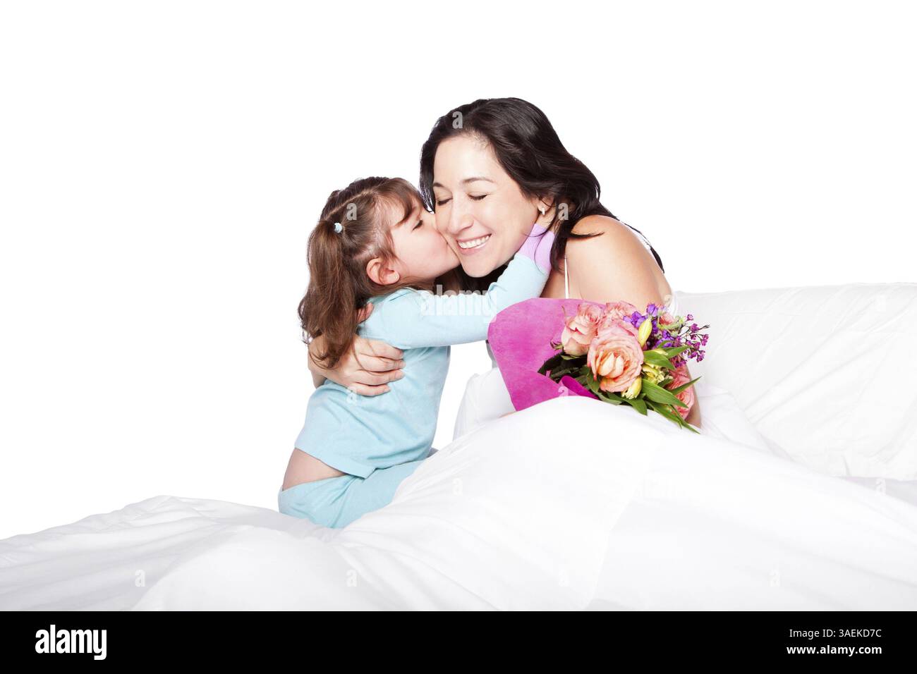 Enfant mignon donnant à la mère au lit un baiser sur la joue et les fleurs, fête des mères ou concept d'hôpital, isolé, Atlanta, USA, Amérique du Nord Banque D'Images