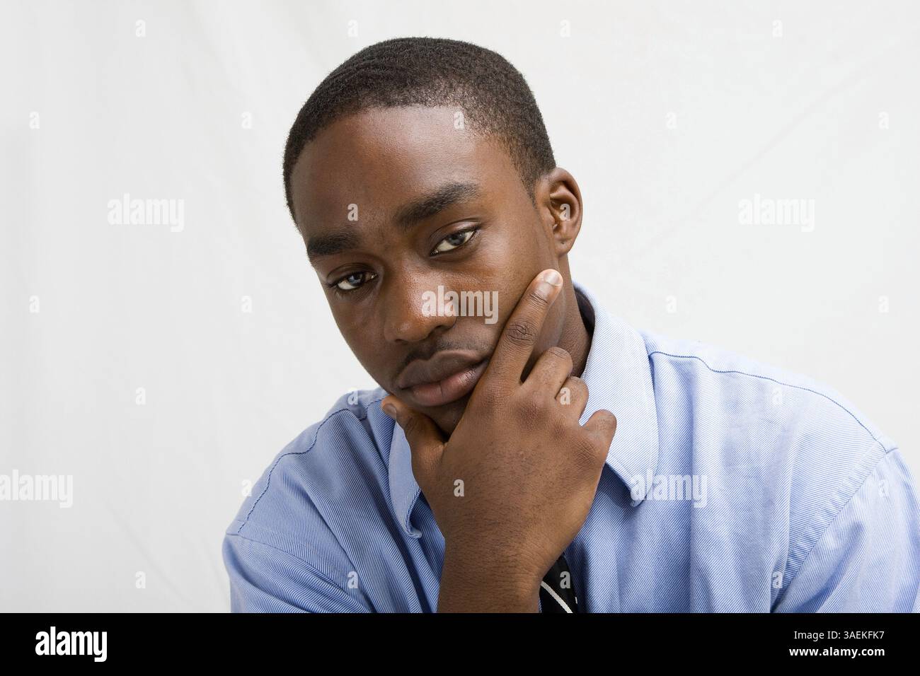 Jeune professionnel des affaires à la peau foncée avec la main sur le menton, étudiant MBA, ou tel, isolé sur blanc, New York, États-Unis, Amérique du Nord Banque D'Images
