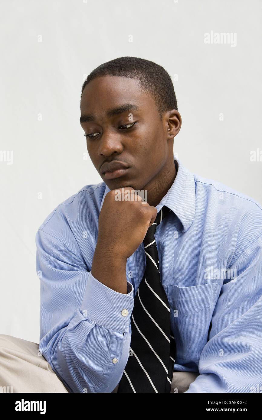 Jeune professionnel des affaires à la peau foncée avec la main sur le menton, étudiant MBA, ou tel, isolé sur blanc, New York, États-Unis, Amérique du Nord Banque D'Images