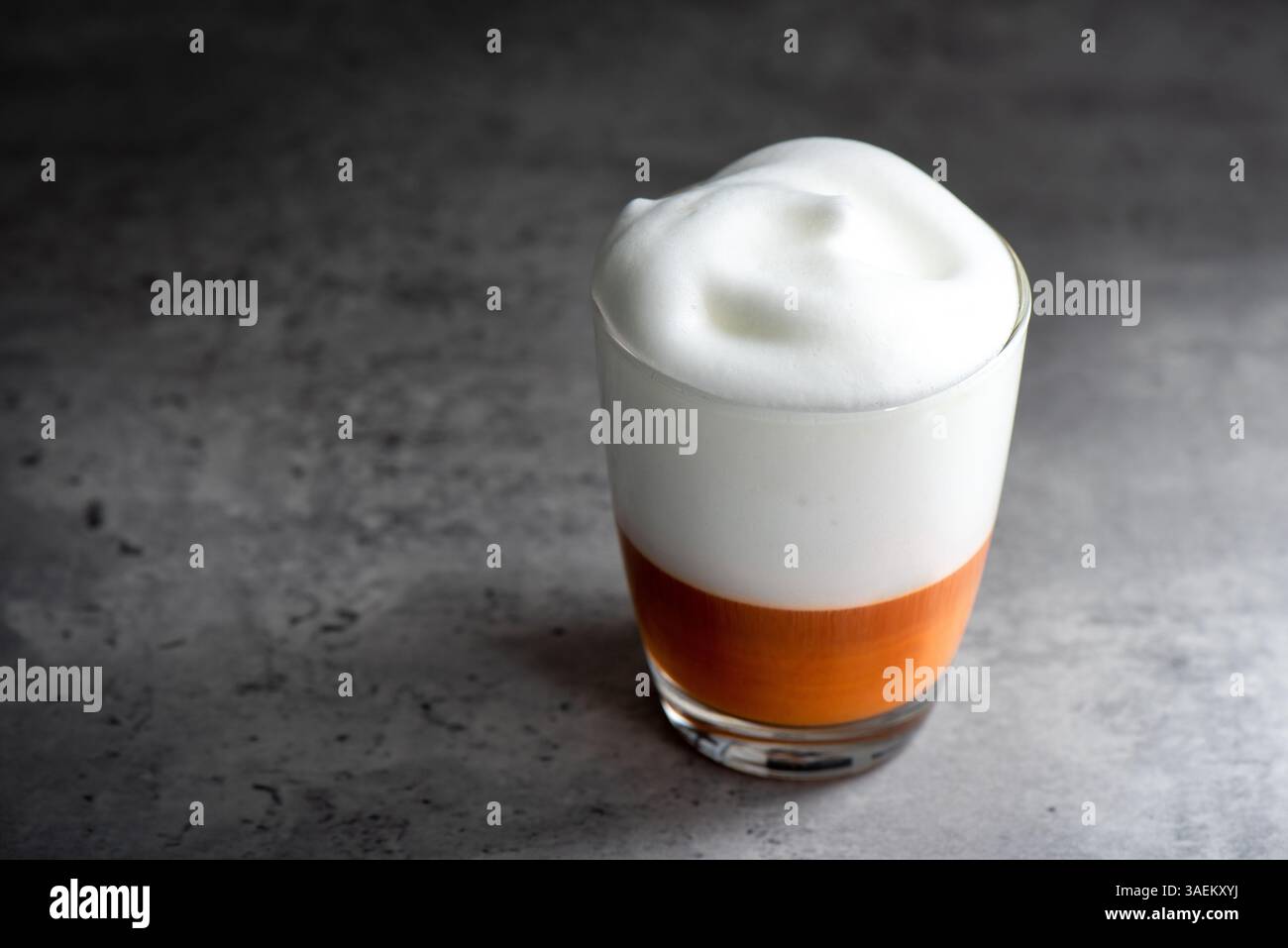 Latte de thé thaïlandais chaud avec mousse de lait dans le verre. Banque D'Images