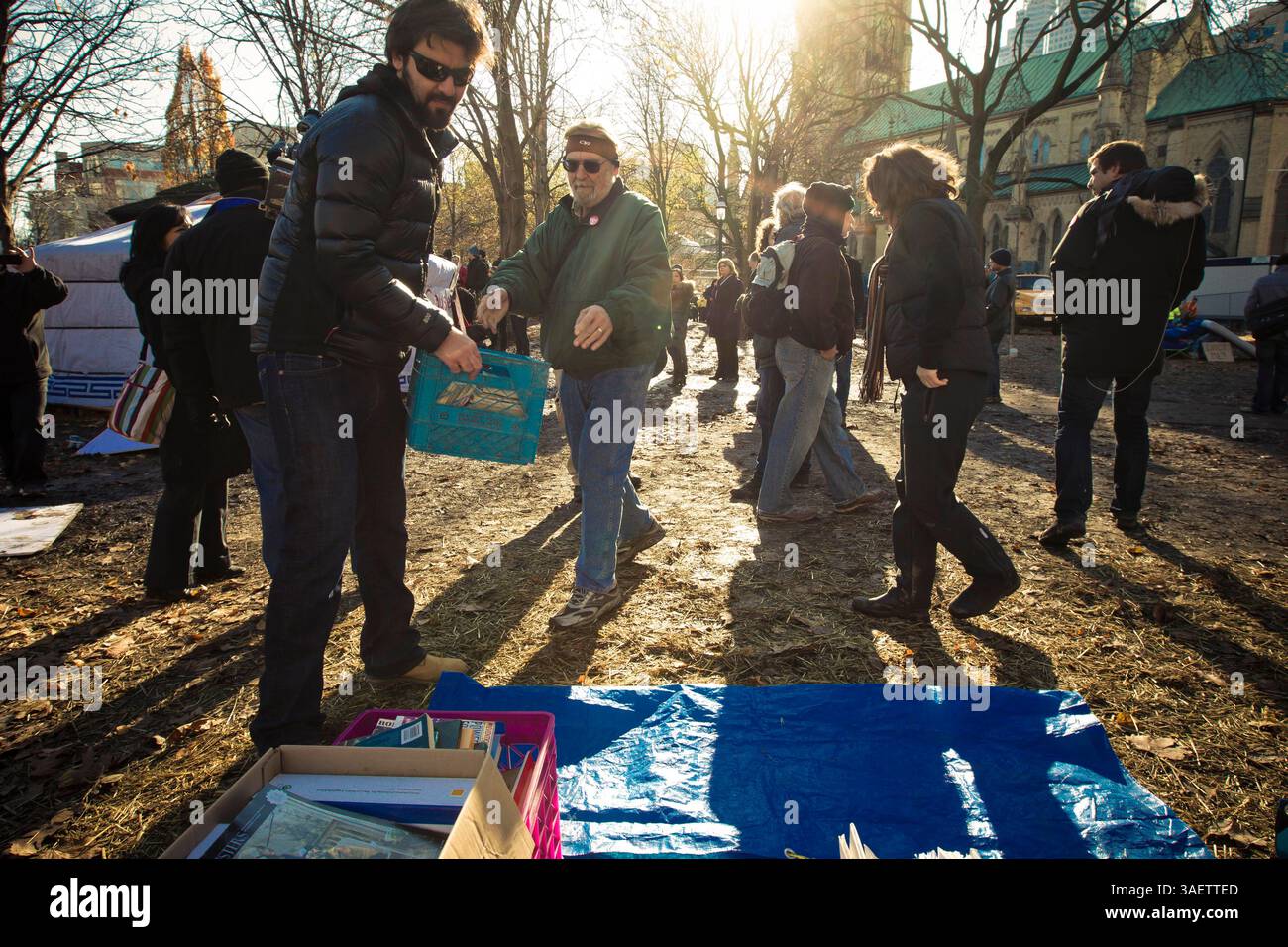 23 novembre 2011 - Toronto, Ontario, Canada - les partisans d'Occupy Toronto arrivent et forment une ligne humaine pour aider à retirer en toute sécurité les livres de la bibliothèque libre de Toronto. Beaucoup craignaient que la police et la ville détruisent les livres et la bibliothèque comme cela s'est passé dans le parc Zuccotti, NY. La police a plutôt donné au public le temps de nettoyer les livres en toute sécurité avant d'enlever les trois manifestants enchaînés à l'intérieur (crédit image : © Chris Drost/ZUMAPRESS.com) Banque D'Images