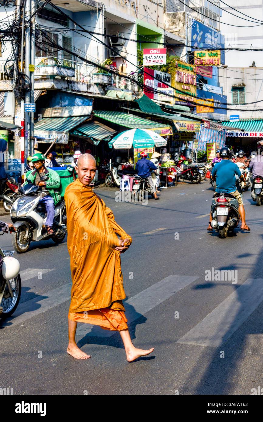 Moine bouddhiste traversant la rue tout en collectant Alms, Go Vap, Ho Chi Minh ville, Vietnam Banque D'Images