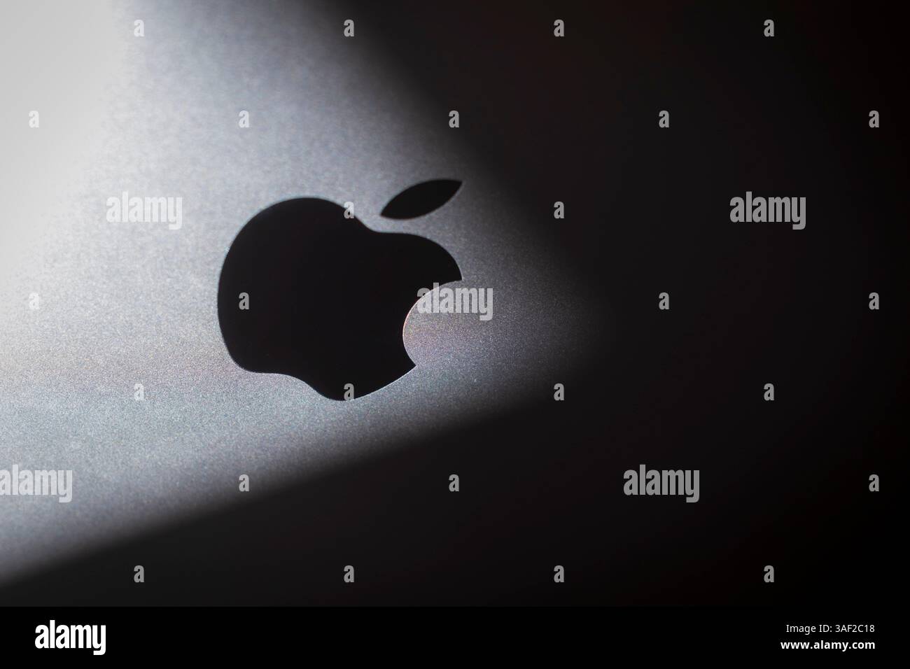 Logo Apple sur un Mac Book avec une ombre épaisse. Photo symbolique pour les gros titres négatifs tels que la chute du cours des actions Banque D'Images