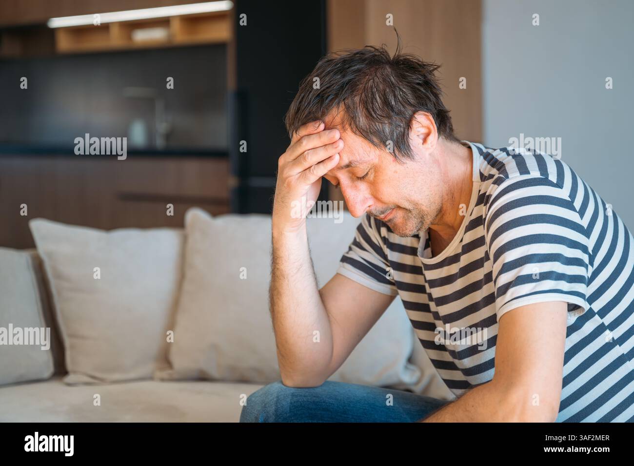 Triste regrettable homme déçu à la maison, concept de santé mentale et de dépression, focalisation sélective Banque D'Images