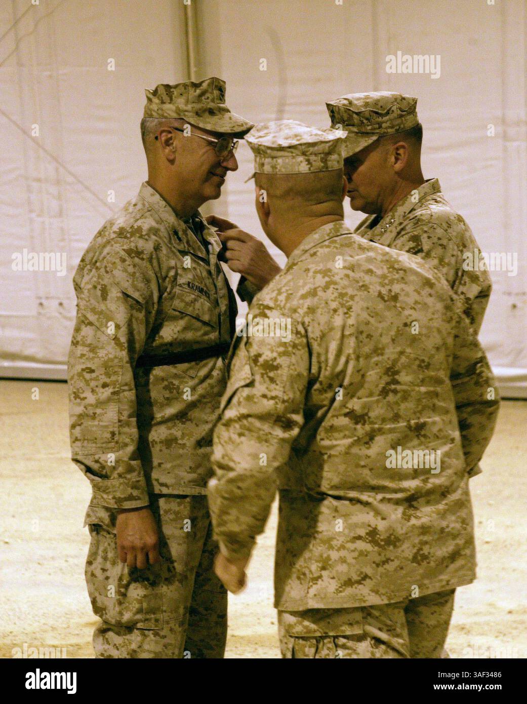 02 janv. 2005 ; Camp Taqaddum, Irak ; Lieutenant Gen. JOHN F. Sattler, à droite, commandant général de la I Marine Expeditionary Force, et 1st FSSG Sgt. Maj. JERRY L. COLE épinglent deux étoiles d'argent chacune sur le col du Maj. Gen. RICHARD S. KRAMLICHÕs Desert-tan, uniforme numérique pendant la cérémonie de promotion au Camp Taqaddum, Irak, 2 janvier 2005. Major Gen. KramlichÕs promotion a réaffirmé les paroles de sagesse heÕs données aux Marines qui ont été récompensées en Irak par leur général commandant. ÒIÕve a eu l'occasion de promouvoir, récompenser et réengager un certain nombre de Marines et de marins depuis IÕve Banque D'Images