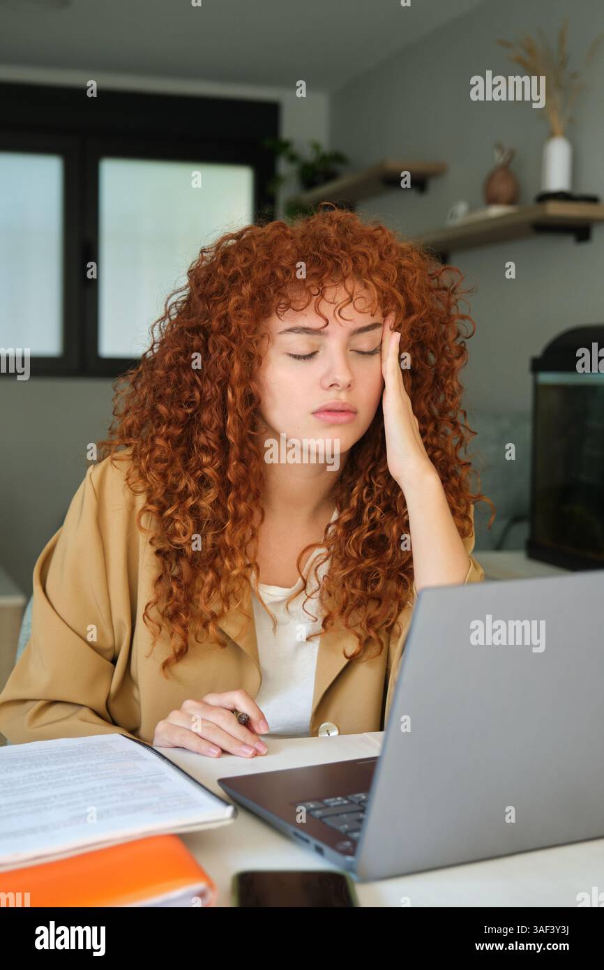 Femme d'affaires fatiguée avec mal de tête travaillant à partir du bureau à domicile Banque D'Images