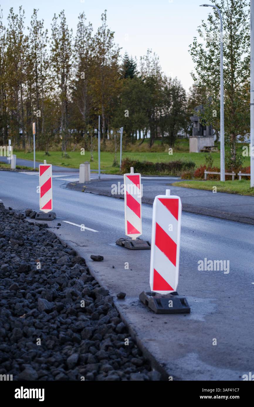 Une route avec des panneaux rayés rouges et blancs sur le côté Banque D'Images