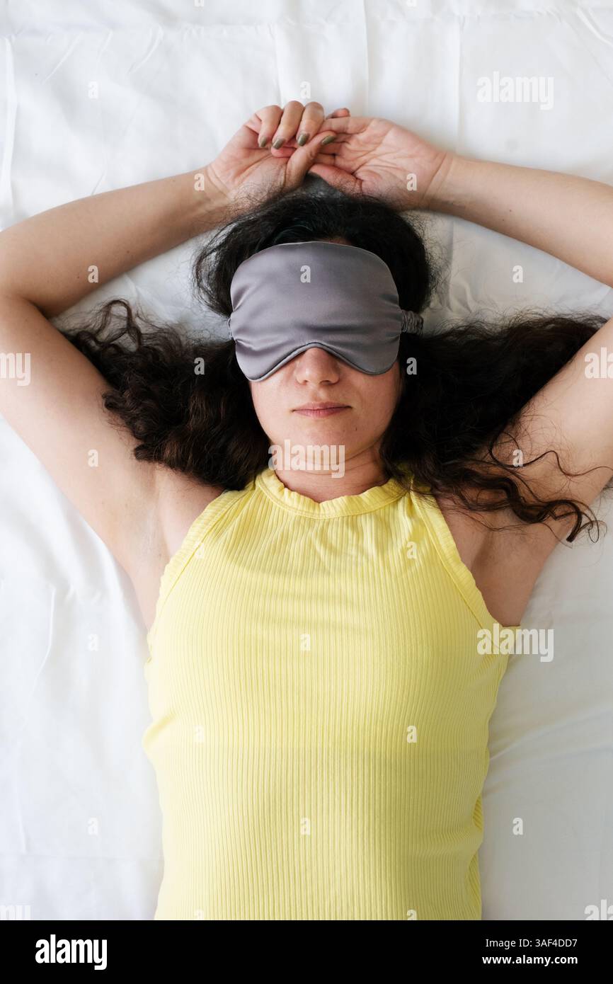 Femme dormant avec masque pour les yeux, santé mentale et relaxation. Banque D'Images