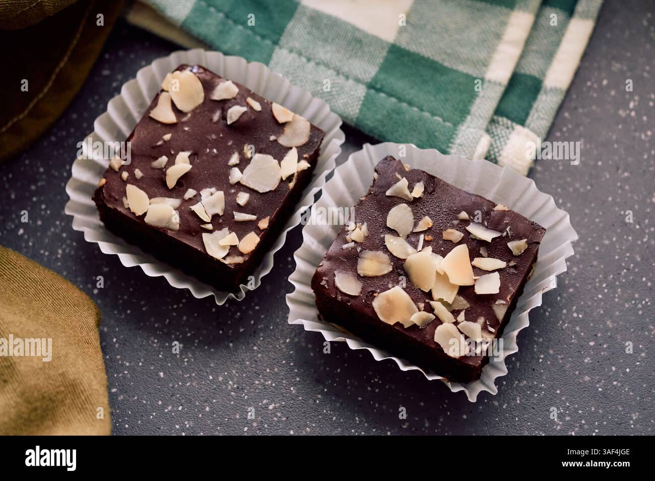 Deux riches brownies au chocolat nappés de tranches d'amandes croquantes Banque D'Images