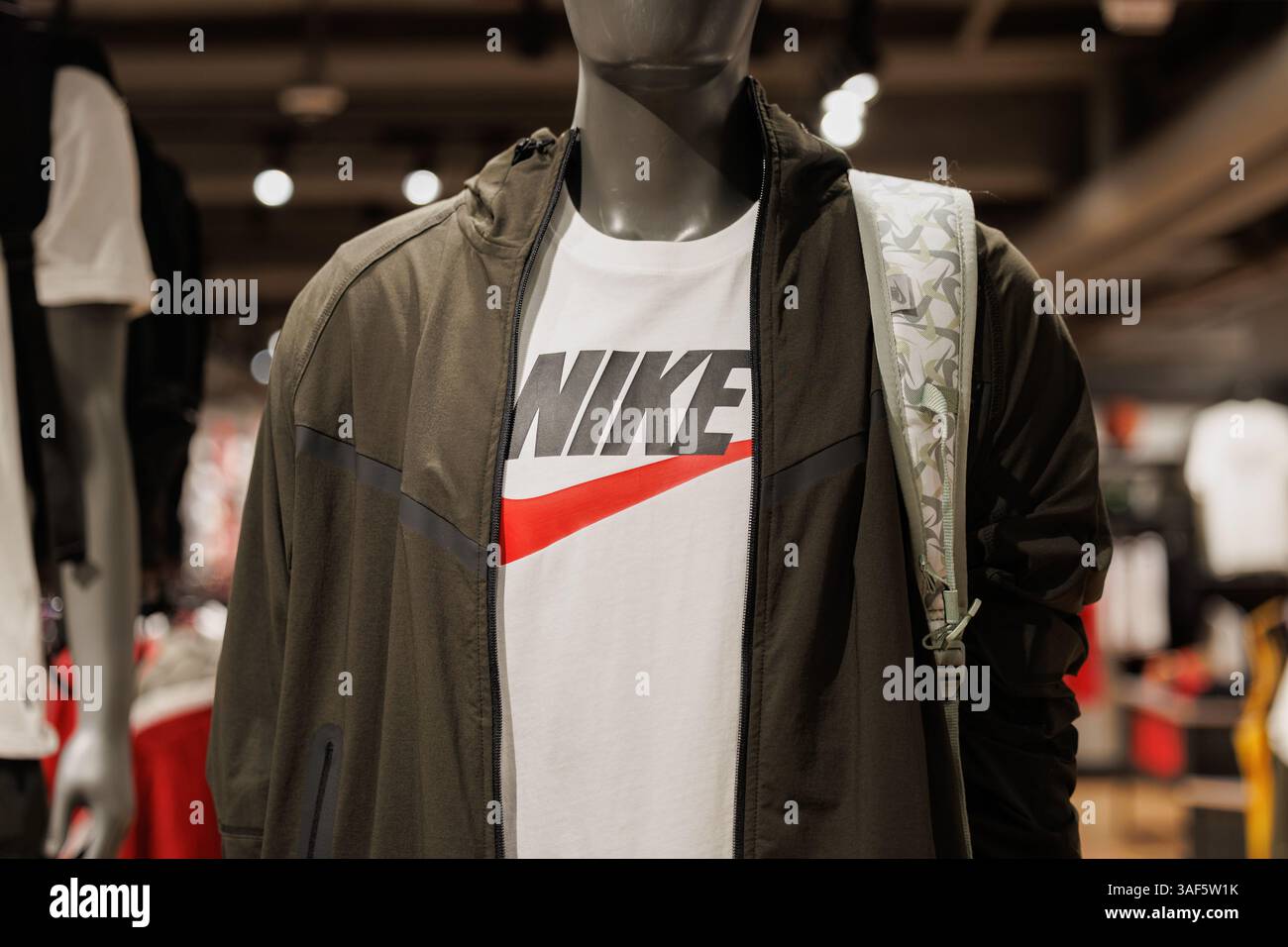 Tissu avec logo Nike à l'intérieur du magasin Nike à Hong Kong. Nike, l'une des plus grandes marques de vêtements de sport au monde, est confrontée à de nouveaux défis alors que le gouvernement américain annonce de nouveaux tarifs douaniers élevés sur les importations en provenance du Vietnam, jusqu'à 49 % sur certains produits. Près de 50% de ses chaussures et 28% de ses vêtements sont fabriqués au Vietnam. Alors que le gouvernement vietnamien a offert de négocier avec les États-Unis, proposant même de supprimer les droits de douane sur les produits américains, Nike n'a donné aucune réponse publique. La situation soulève de grandes questions sur la hausse des coûts, les retards possibles et la manière dont les marques géreront les risques liés à la chaîne d’approvisionnement à l’avenir. Banque D'Images