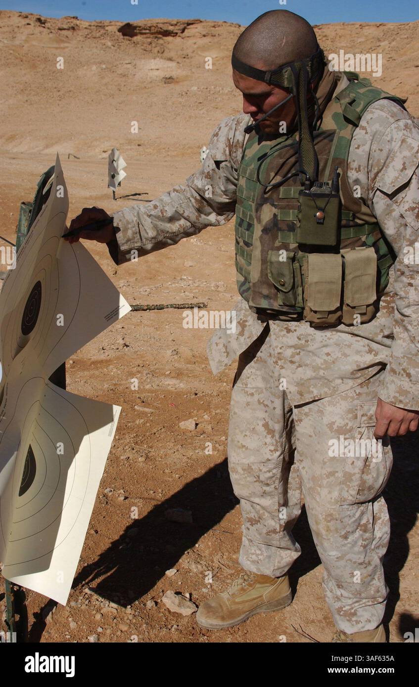 25 janvier 2005 ; Al Asad, Irak ; Sgt. JESUS E. VILLEGAS, 26 ans natif de Chicago et artilleur de défense aérienne à basse altitude avec opérations de tir et entraînement, 4e bataillon de défense aérienne à basse altitude, bataillon de sécurité, Marine Wing support Group 37, 3e escadre aéronautique des Marines, cherche des trous de balles sur le champ de tir lors d'une compétition tenue à Al Asad, Irak, janvier 25. La compétition d'une semaine organisée par le bataillon de sécurité couvrait tous les systèmes d'armes, du pistolet M-9 à la machinerie Cal .50. Banque D'Images