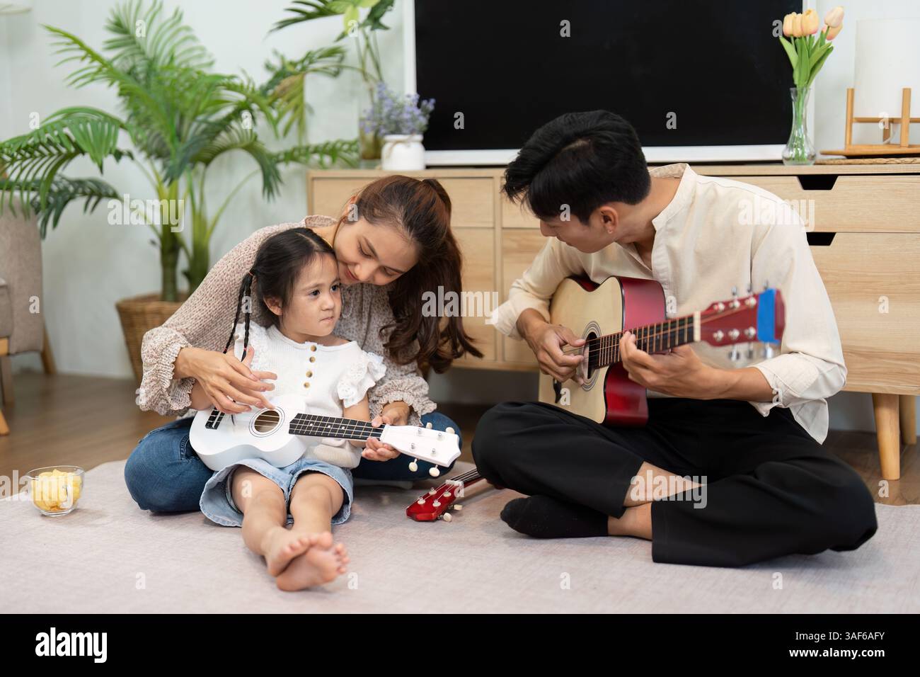 Moments musicaux en famille. Une mère et sa fille se liant tout en jouant des instruments. Banque D'Images