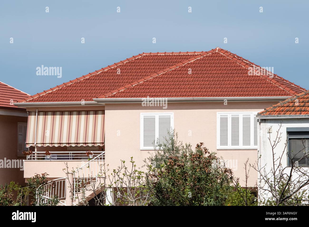 Toit de maison, style contemporain sur fond de ciel bleu. Une vue de maison vintage typique avec toit de tuiles. Maison avec toit en tuiles espagnoles. Toit en tuiles orange Banque D'Images