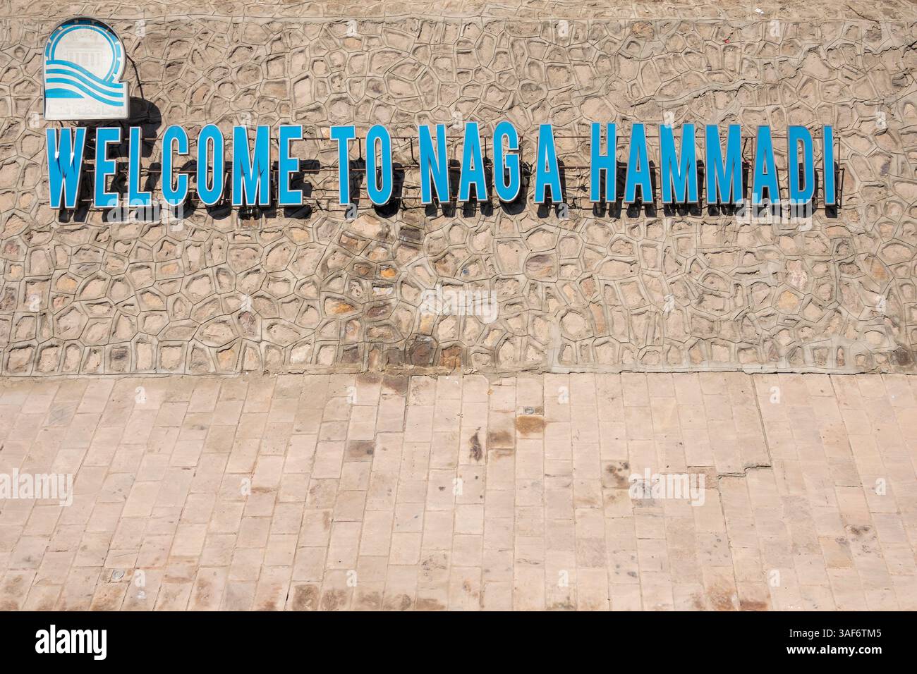 Panneau de quai de rive du Nil avec lettrage découpé en bleu accueillant des navires à la ville de Naga Hammadi, haute-Égypte Banque D'Images