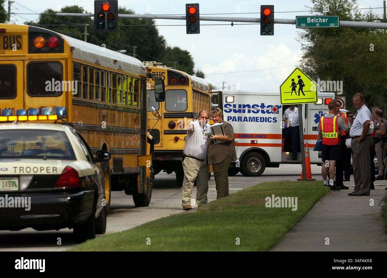 Accident de bus. 24/9/2003-- George Francey, spécialiste de la formation en transport, discute avec Vickie Barker, coordonnatrice des opérations sur le terrain, d'une épave qui impliquait deux autobus scolaires et deux voitures. Les deux travaillent pour le conseil scolaire du comté de Pinellas. Les quatre véhicules se dirigeaient vers l'ouest sur Tampa et se préparaient à tourner à droite sur Belcher. Le feu est devenu vert, mais les gardes de passage avaient arrêté la circulation. Tous les véhicules se sont arrêtés sauf le dernier bus, claquant dans le deuxième bus, qui a été poussé dans une camionnette, la camionnette a ensuite heurté la première voiture en ligne. Le chauffeur du dernier bus, Carol S. Keith, était cit Banque D'Images
