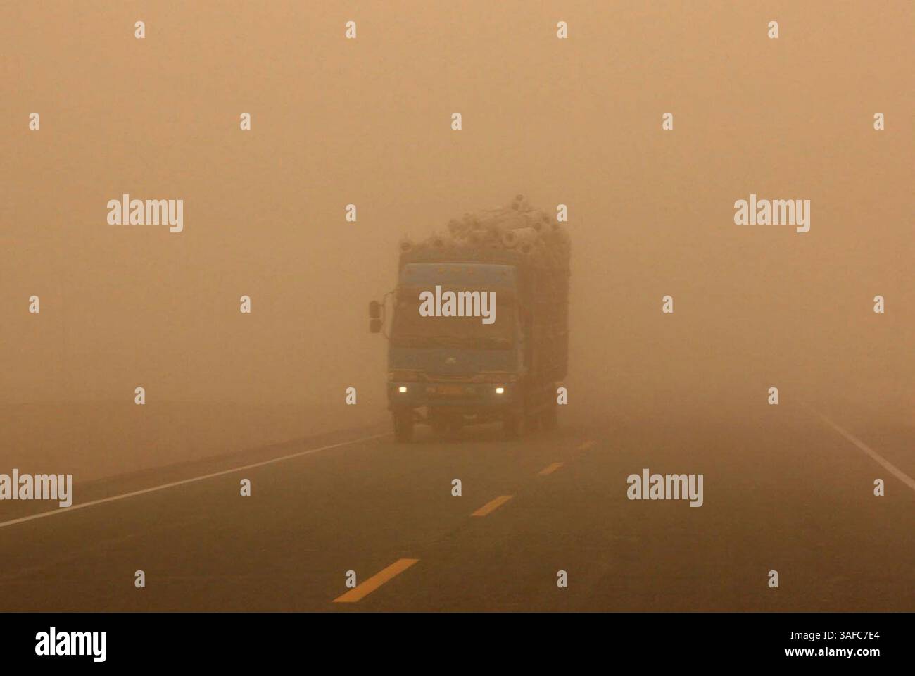 05 août 2008 - Xinjiang, Chine - Un camion est enveloppé de poussière flottante sur l'autoroute reliant le comté de Kuqa et le comté de Bugur dans la région autonome ouïgur du Xinjiang, au nord-ouest de la Chine, le 5 août 2008. Mardi, une forte tempête de sable frappe la région sud du Xinjiang, provoquant une chute soudaine de la température de 40 à 23 degrés Celsius (crédit image : ZUMA Press/ZUMAPRESS.com) Banque D'Images