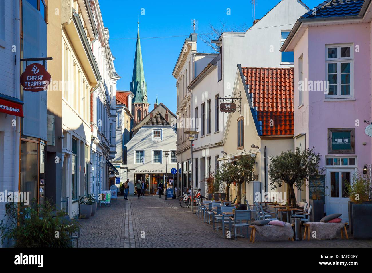 Oldenburg, Niedersachsen, Deutschland - Historischer Stadtkern, hier die Burgstrasse in der Fussgaengerzone, hinten die sont Lambertikirche Oldenburg, eine Sehenswuerdugkeit in der Altstadt Oldenburg. Die Fussgaengerzone ist gepraegt von historischen Bauwerken, kleinen Gassen, einer Vielfalt inhabergefuehrter Ladengeschaefte und gastronomischer Angebote. Rechts das Restaurant Kleine Burg. Oldenburg Niedersachsen Deutschland *** Oldenburg, basse-Saxe, Allemagne Centre historique, ici la Burgstrasse dans la zone piétonne, derrière l'église St Lamberti Oldenburg, une vue dans la vieille ville Olde Banque D'Images