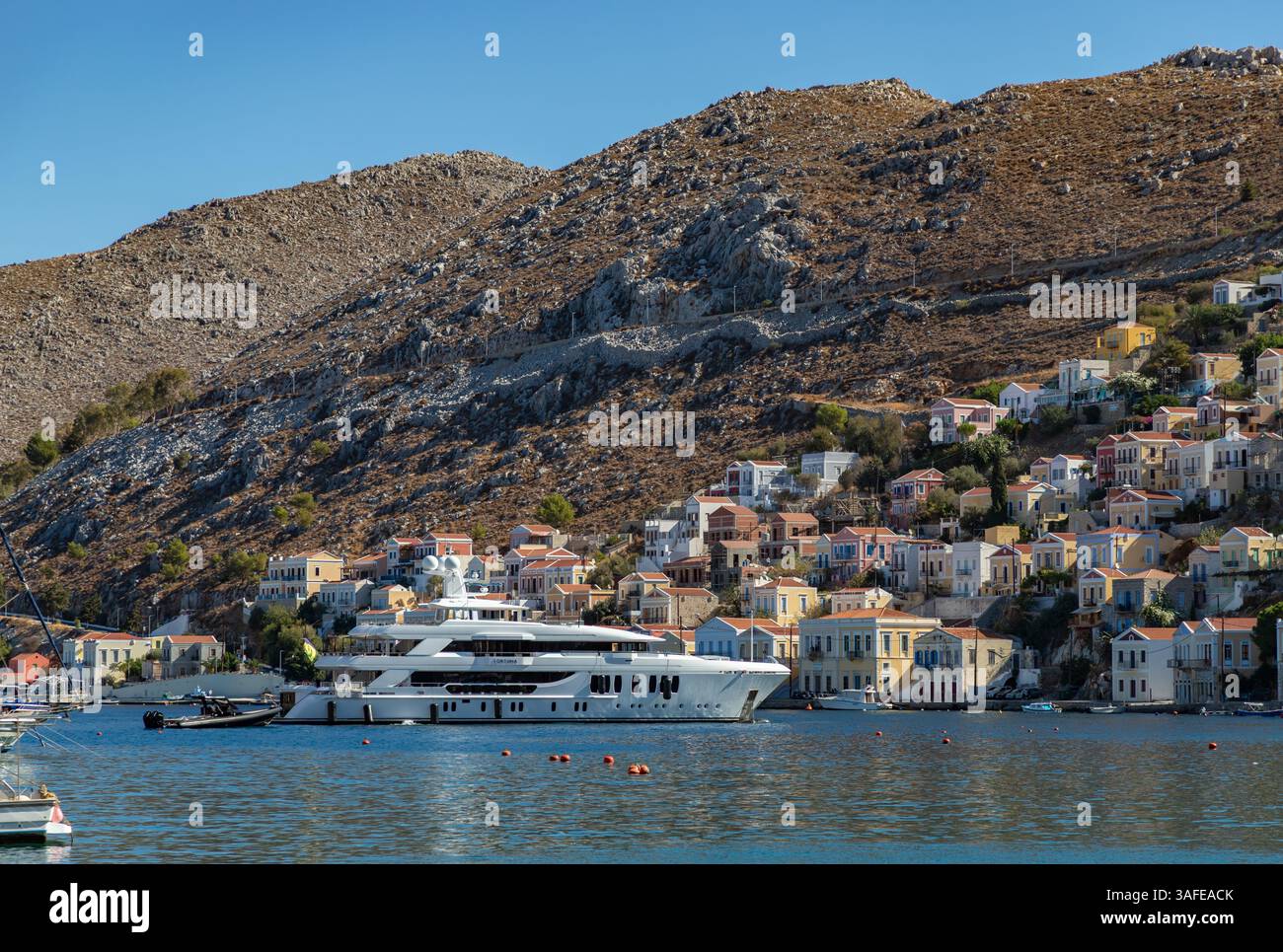 Photo d'un yacht ancré sur la ville colorée d'Ano Symi sur l'île de Symi. Banque D'Images