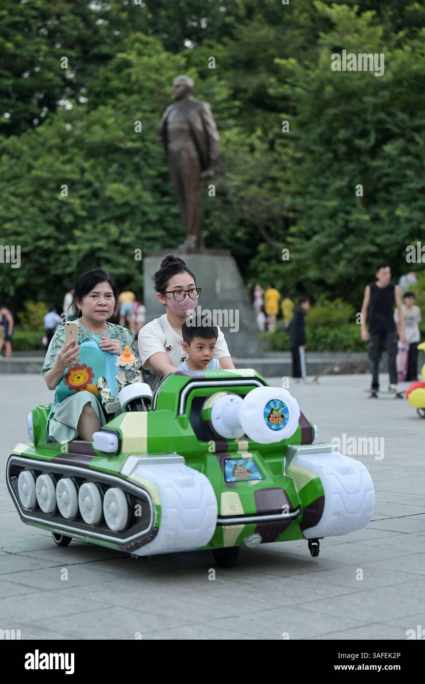 VIETNAM, ville de Hanoi, guerre du Vietnam aujourd'hui, place de Lénine et statue de Lénine, les enfants conduisent le jouet de réservoir en plastique mobile / Lenin Platz mit Lenin Skulptur, Kinder fahren mit Spielzeug Panzer aus Plastik Banque D'Images