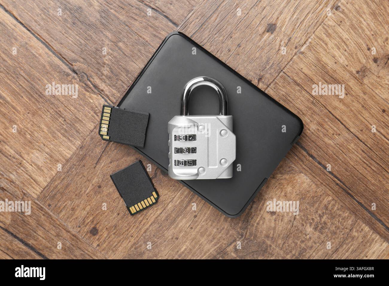 Disque dur externe, cartes mémoire SD et cadenas à combinaison sur table en bois, plat Banque D'Images