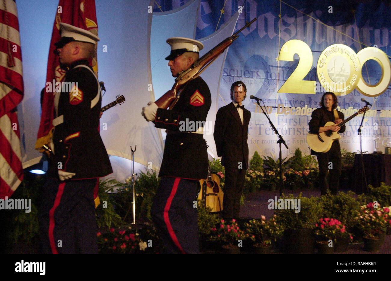 Après avoir chanté l'hymne national au début du banquet de célébration du 20e anniversaire du Washington Times à Washington, D.C. Randy Travis, troisième à partir de la gauche, regarde le Color Guard descendre de la scène. Mardi 21 mai 2002. (Crédit image : The Washington Times/ZUMAPRESS.com) Banque D'Images