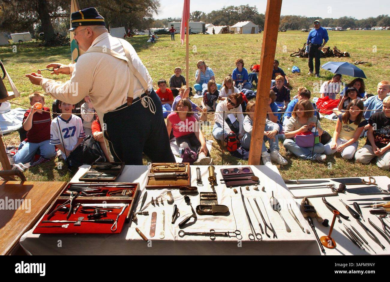 Résumé de l'histoire : des élèves des écoles de la région visitent le site de la reconstitution annuelle de la guerre civile de nature Coast ce week-end à Red Level, au nord de Crystal River vendredi après-midi (03/12/2004) pour en apprendre davantage sur l'histoire de la guerre entre les états....LÉGENDE : 03/12/2004--RED LEVEL----Tom Aloisio (cq), colonel Lt. dans l'hôpital de campagne de la 4e brigade démontre des outils médicaux de la guerre civile aux élèves de l'école primaire Rock Crusher vendredi matin (image : St Petersburg Times/ZUMAPRESS.com) Banque D'Images