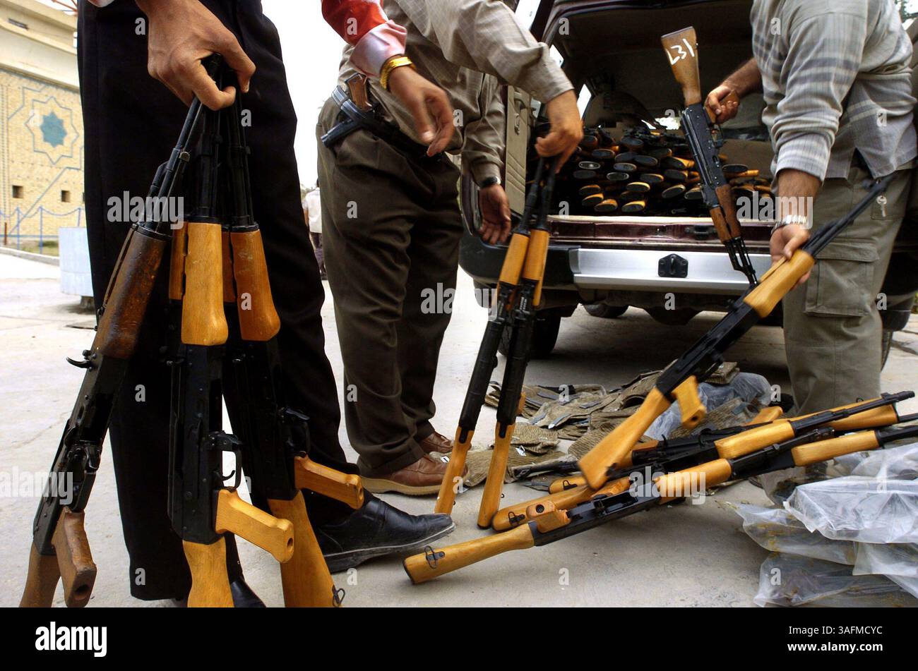 Les Irakiens travaillant pour le réseau irakien Media Network déchargent plus de 500 AK-47 de l'arrière d'un 4x4 Nissan dans la future maison de leurs studios de télévision à Bagdad. Les armes seront utilisées par les gardes postés sur chacun des 34 sites d'IMN à travers le pays. Le Harris Corp. gère le contrat de plusieurs millions de dollars pour aider les médias irakiens à se mettre sur pied et a estimé qu'IMN avait besoin de plus de protection après une attaque sur un bus de ses employés tués trois, dont une jeune femme ancre. (Crédit image : St Petersburg Times/ZUMAPRESS.com) Banque D'Images