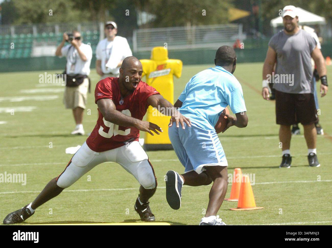 Camp d'entraînement de football Buccaneer de Tampa Bay au Disney Wide World of Sports. Les photos ont été prises mardi (3/08/04) et toutes les pièces D'identité sont de la liste officielle.***photo 8. Environ 15 Olympiens spéciaux ont regardé la pratique du Buc depuis des sièges VIP, puis ont participé avec les joueurs après la pratique en faisant divers exercices avec eux. Sur la photo, Ian Gold tente de s’attaquer à Curtis Lester, l’olympien spécial (crédit image : St Petersburg Times/ZUMAPRESS.com) Banque D'Images