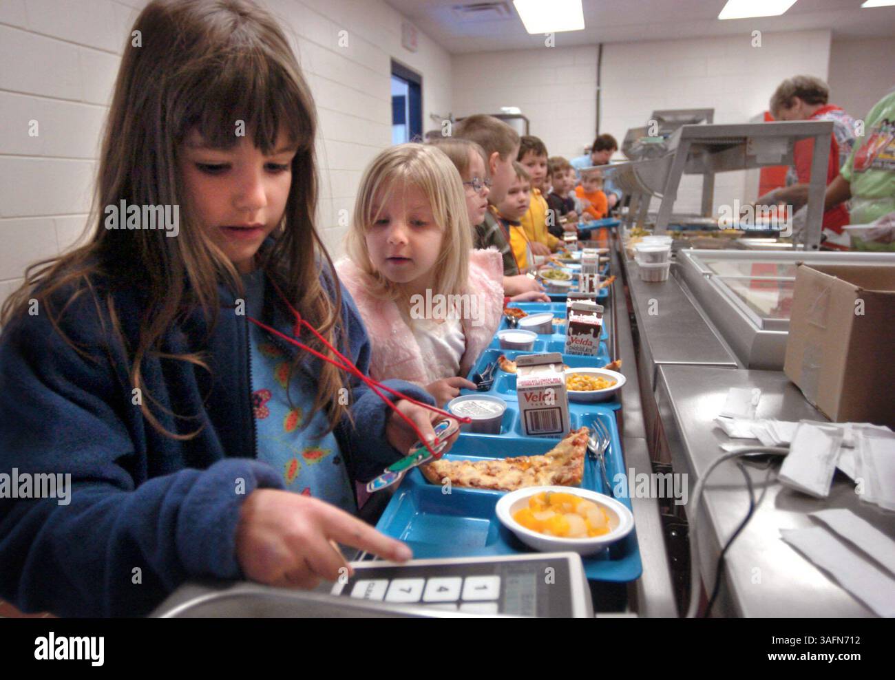 LÉGENDE : (24/01/2005, Inverness) Brooke Parmenter, première année d'Homosassa, frappe son code déjeuner pour la première fois lundi (24/01/05) tandis que sa camarade de classe Jasmine Blaylock attend son tour. Pour la première partie de cette année, le portable utilisé comme salle à manger n'a pas été câblé pour l'utilisation du code..GENERAL : après un retard de cinq mois en raison d'une construction médiocre, la cafétéria élémentaire Homosassa a ouvert aux étudiants pour la première fois lundi (Credit image : St Petersburg Times/ZUMAPRESS.com) Banque D'Images