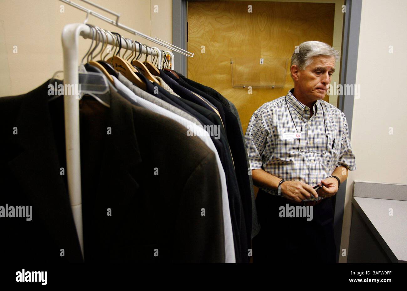 TP 247760 WALL Homeless 1.(Tampa -- 21/08/2006) PHOTO 1 : George Hannah, gestionnaire de cas pour l'Armée du Salut, se tient debout dans la petite salle pour que les résidents trouvent des vêtements de travail. Il y a une petite sélection de vêtements élégants pour hommes, le problème est que plus de vêtements de travail comme les jeans bleus, les bottes à bout en acier et les chemises de travail sont nécessaires. . RÉSUMÉ DE L'HISTOIRE : la Maison de l'espoir pour hommes de l'Armée du Salut organise des cours d'habiletés de vie quotidienne tous les lundis soirs, où les résidents apprennent à équilibrer les chéquiers et à adopter un mode de vie sain. La clé est de les rendre employables, et vous ne pouvez pas obtenir un emploi à moins de vous habiller pour le succès. C'est whe Banque D'Images