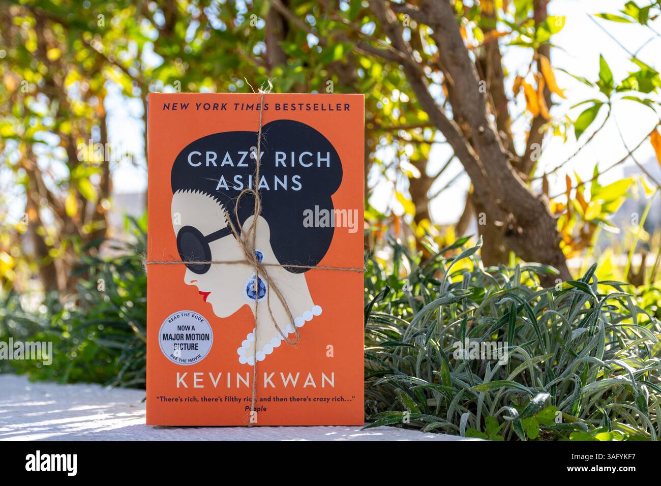 Gros plan du livre Crazy Rich Asians de Kevin Kwan dans le jardin. Roman comique romantique. Banque D'Images