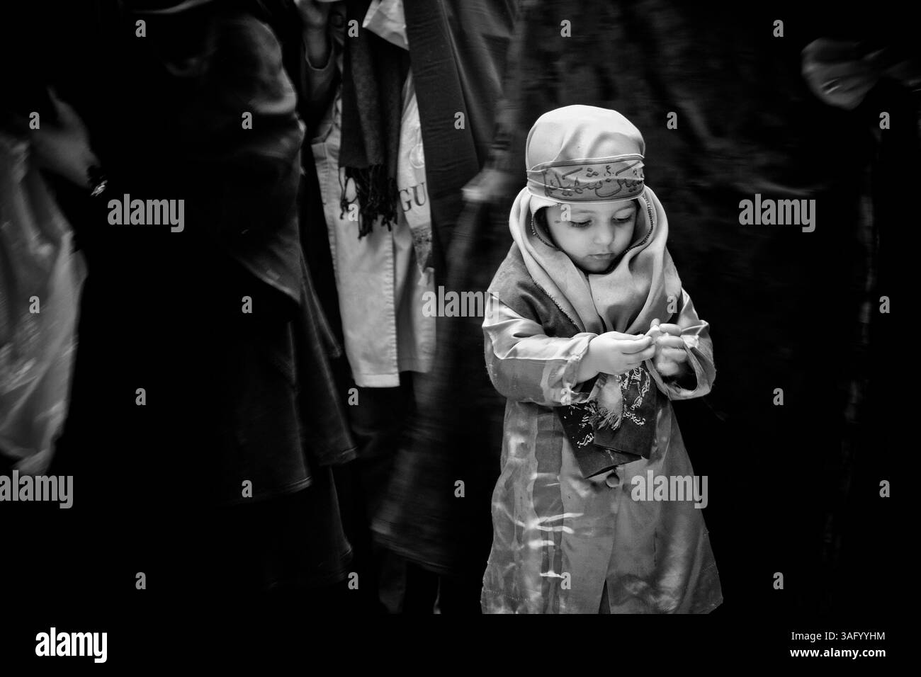 Dec. 5, 2011 - Khorramabad, Iran - chaque année pour marquer la mort de l'Imam Hussein, les musulmans chiites pleurent pendant deux jours. À Khorramabad et Lorestan, dans l’ouest de l’Iran, lors du premier jour de deuil, appelé Tasooa, les femmes font vœu de silence et traversent les rues avec les enfants allumant des bougies. À 4 heures du matin sur Ashura, le deuxième jour, les hommes se couvrent de boue et se tiennent devant un feu jusqu'à ce que la boue ait séché pour devenir argile. Après cela, ils vont à la mosquée et prient (crédit image : © Farhad Babaei/ZUMAPRESS.com) Banque D'Images