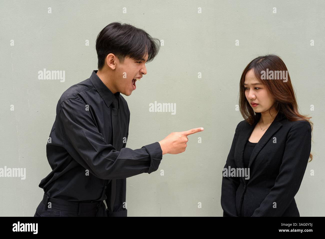 Portrait d'un jeune couple asiatique portant un uniforme d'affaires sur fond Uni Banque D'Images
