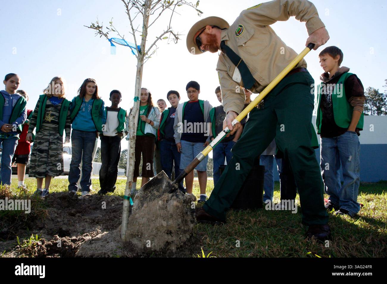 LÉGENDE : (LAND O'LAKES 01/26/2008) Arthur Clothier, Forester Senior du comté de Pasco le Centre forestier Withlachoochee pelle la terre alors qu'il aide les élèves de la patrouille terrestre de l'école primaire Pine View à planter un chêne vivant pour une célébration de la Journée de l'arbre à l'école le vendredi matin 25/01/2008. Tout le corps de l'école s'est avéré être témoin de l'événement. La patrouille terrestre est un programme scolaire composé d'élèves de 5e année qui surveillent le campus pour les questions environnementales, de sécurité et de recyclage et, dans ce cas, aident à planter leur arbre Arbor. .Pt (crédit image : St Petersburg Times/ZUMAPRESS. Banque D'Images