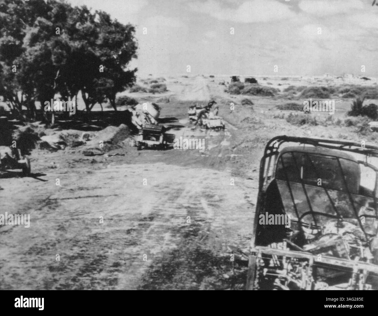 Trou de boue du désert - un char de l'axe abandonné et plusieurs véhicules légers alliés sont tombés victimes de ce trou de boue dans le désert occidental alors que la huitième armée britannique poursuivait les unités de l'axe en fuite. Le trou de boue a été causé par de fortes pluies. 25 novembre 1942. (Photo de AP Wirephoto). Banque D'Images
