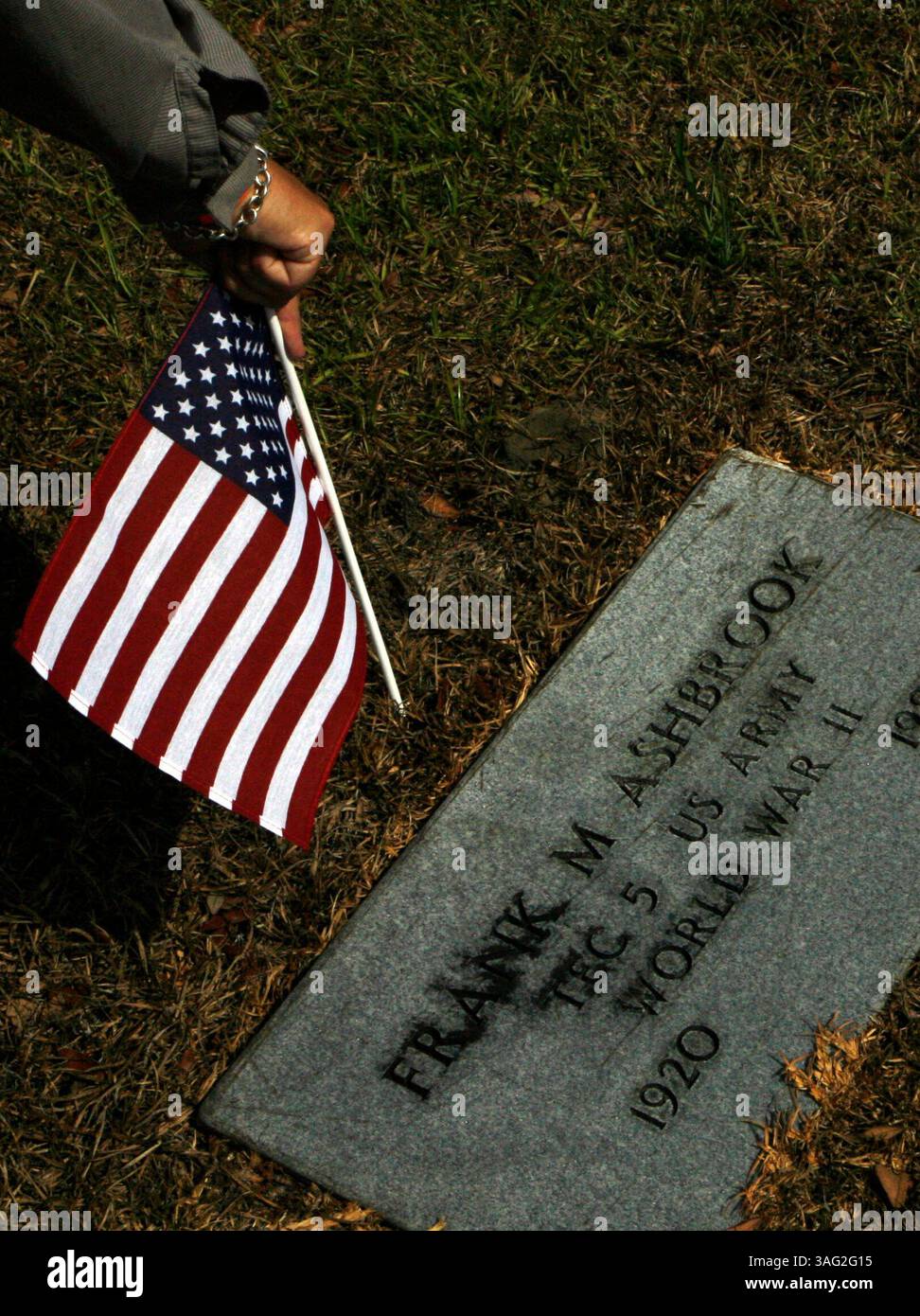 LÉGENDE : (Dade City 05/21/2008) Edward Gorecki (cq) un résident de Dade City et un agent d'application de la loi à temps partiel et vétéran de la Force aérienne place un drapeau sur la tombe d'un vétéran au cimetière de Dade City tandis que la gardienne du cimetière Mariarose Kussler se tient derrière lui avec une presse-papiers des tombes des vétérans et un bras plein de drapeaux américains. .. (Crédit image : St Petersburg Times/ZUMAPRESS.com) Banque D'Images