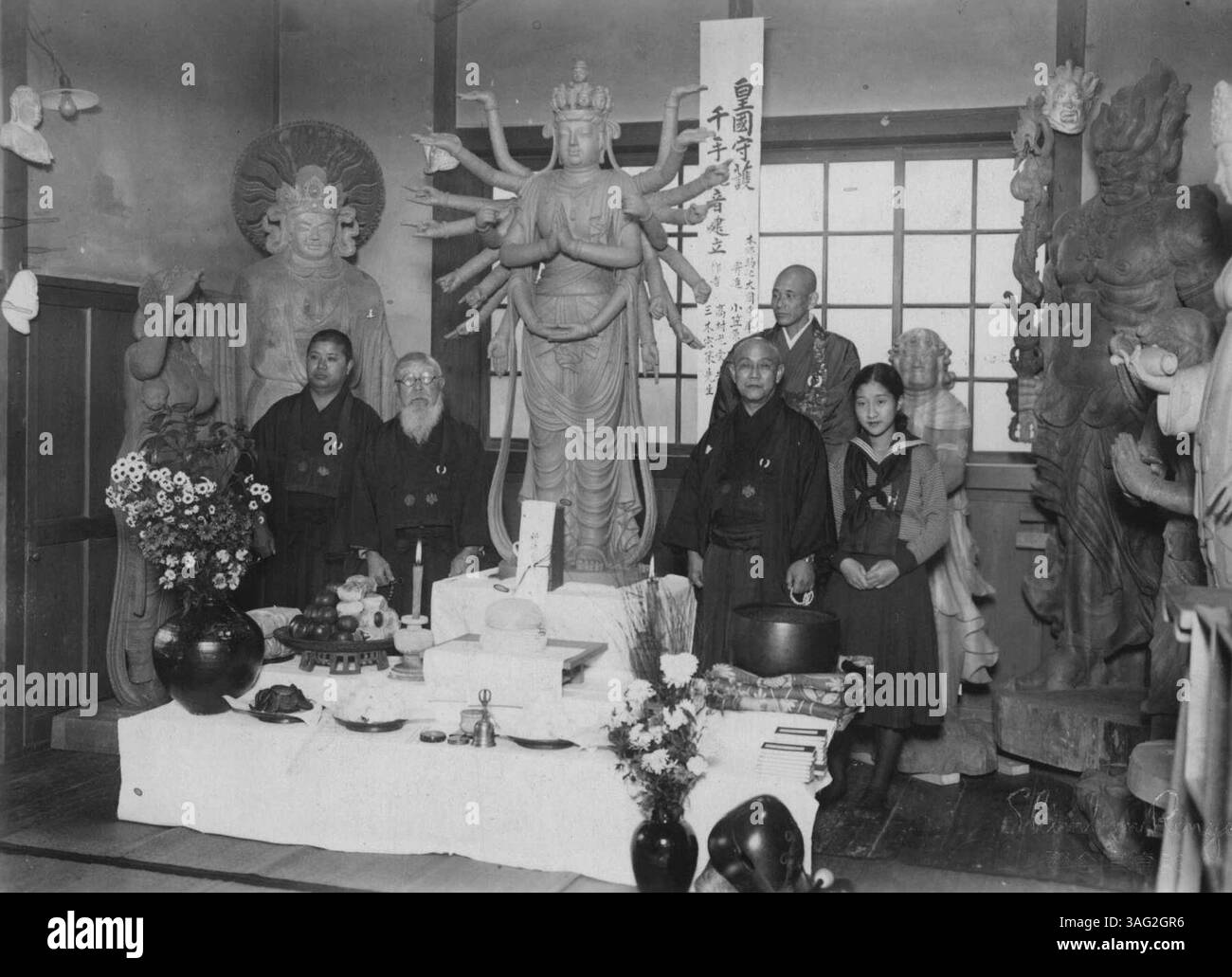 De gauche à droite, MM. Miji, Takamura, le comte Ogasahra (arrière prêtre de Daienji) et Mlle Hiroko Ogasahara, fille à l'image de Budda. Une grande image de Budda, nommée Senju Knnon en japonais, a achevé sa construction par les graveurs Budda renommés, Mr. Koun Takamura et Sosaku Miki. Cette image de Budda a été donnée à un temple, Daienji, à Tokyo pour la prospérité nationale par le comte Chosei Ogasahara. 15 décembre 1932. (Photo de Shimbun Rengo Newsreel photo Service). Banque D'Images