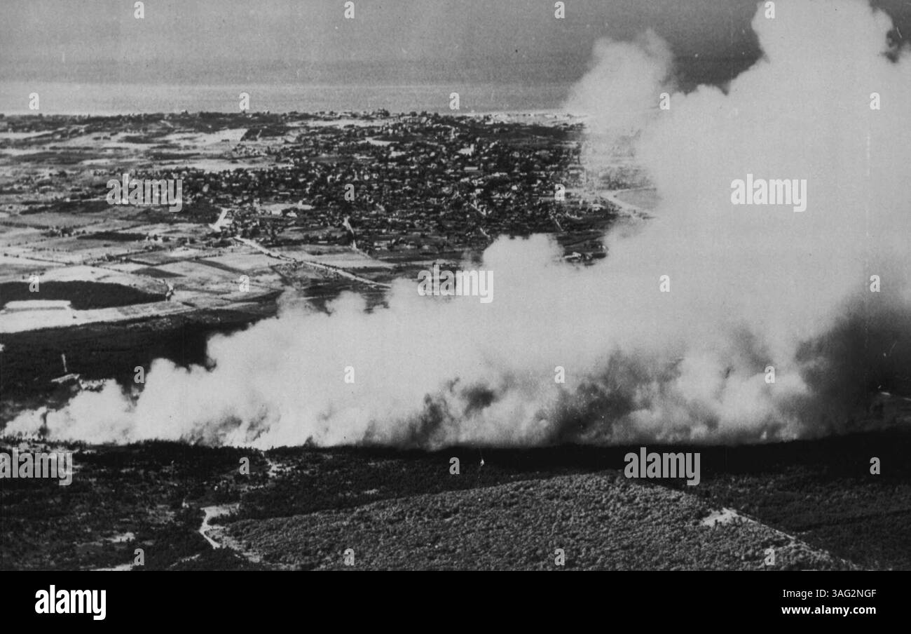 Forest Fire Rages on Island -- Un énorme panache de fumée s'échappe en plein ciel, tandis qu'un broussailles et des courses de feu de forêt traversent les bois de cette île du complexe. Il a menacé l'aéroport et a brûlé plus de plusieurs kilomètres carrés avant d'être contrôlé. La ville de Nantucket se présente en arrière-plan. 24 juillet 1949. (Photo par AP Wirephoto). Banque D'Images