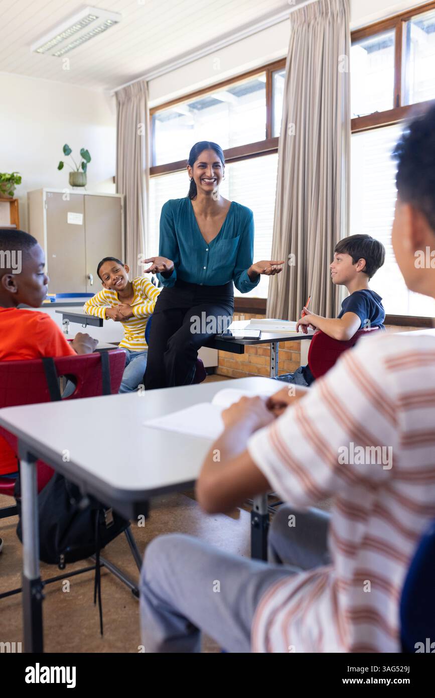 S'engager avec les élèves en classe, enseignante indienne à l'école souriante et interagissant Banque D'Images