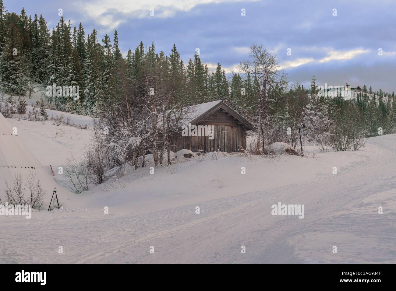 une petite cabane sur la pente d'une montagne enneigée Banque D'Images