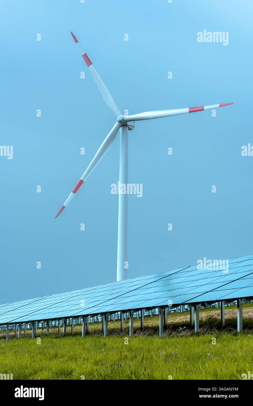 Image verticale minimaliste avec des panneaux solaires et une éolienne sur un terrain vert en Allemagne Banque D'Images