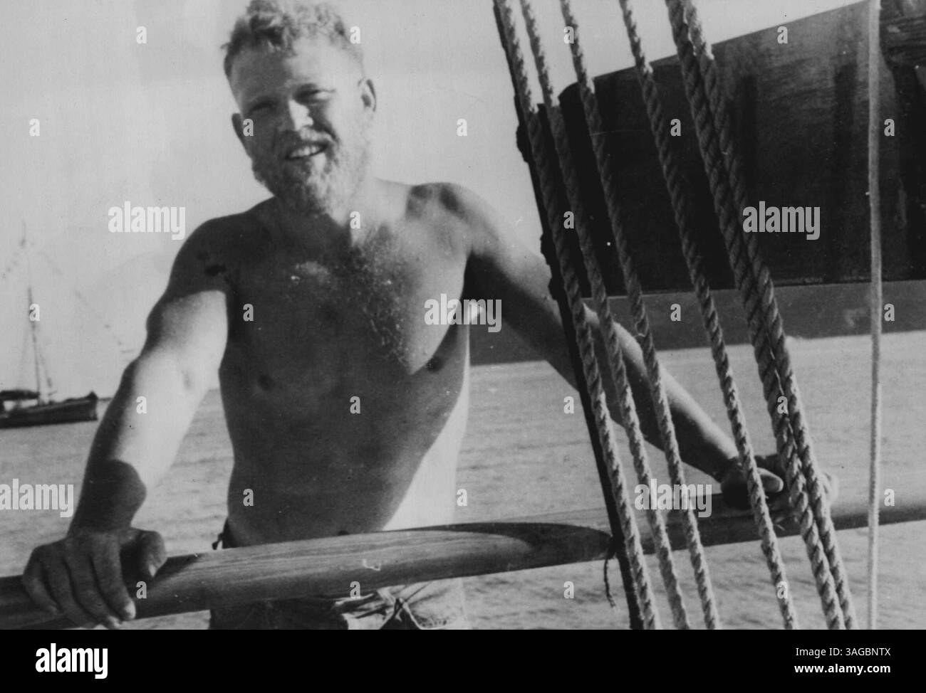 Blond barbu Caldwell, Husky et endurci par sa vie en plein air, pose sur le rail du stout Ketch, Tropic Seas, dans lequel lui, sa femme et ses trois enfants traversent le pacifique. 11 décembre 1953. Banque D'Images