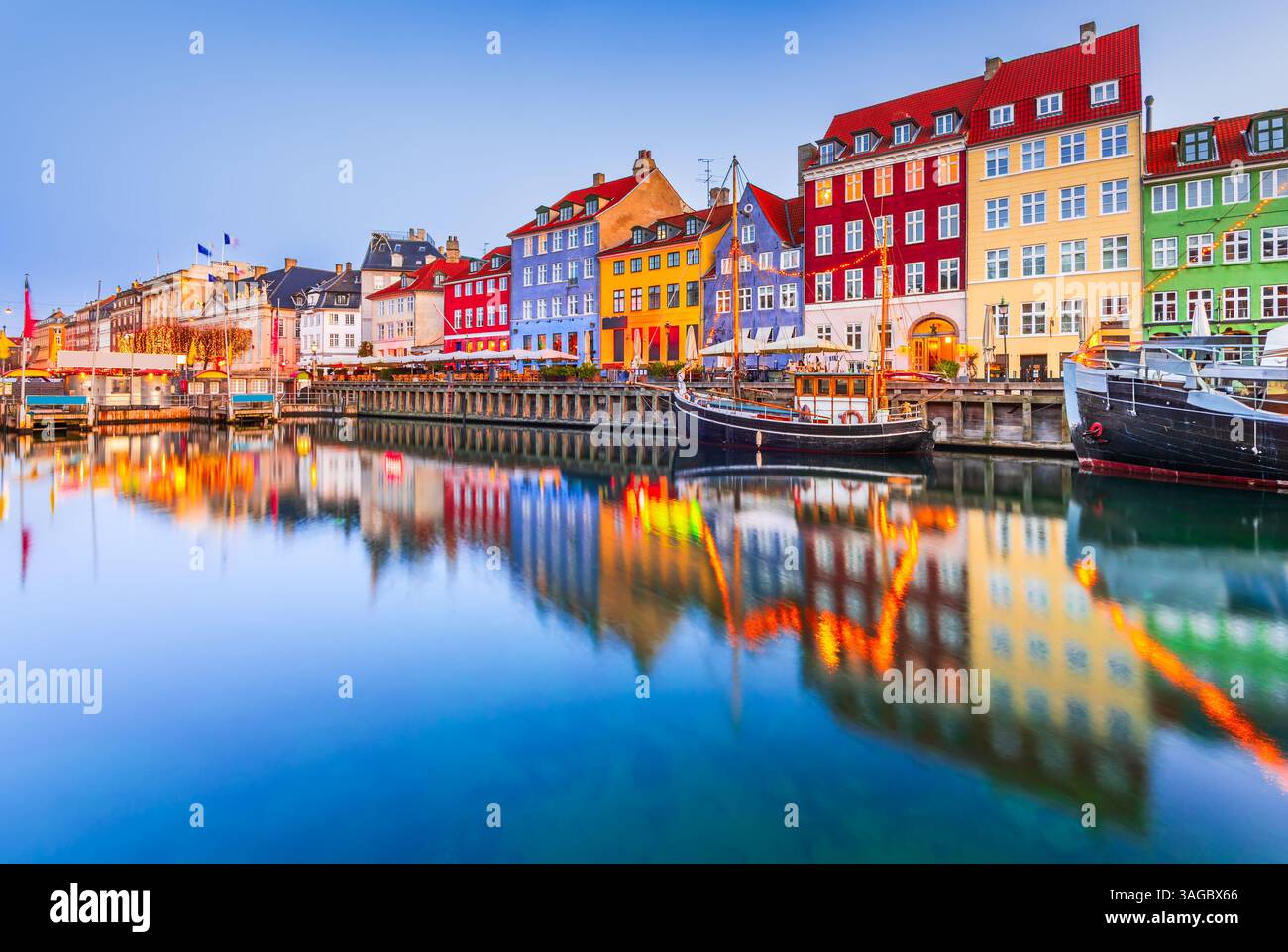 Copenhague, Danemark. Nyhavn. canal d'eau emblématique dans le crépuscule coloré du matin avec des reflets d'eau à couper le souffle. Banque D'Images Copenhague, Danemark. Nyhavn. canal d'eau emblématique dans le crépuscule coloré du matin avec des reflets d'eau à couper le souffle. Banque D'Images