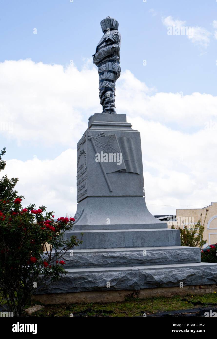 Un monument aux soldats confédérés est recouvert de plastique sur la place de la ville de Tuskegee Alabama. Banque D'Images
