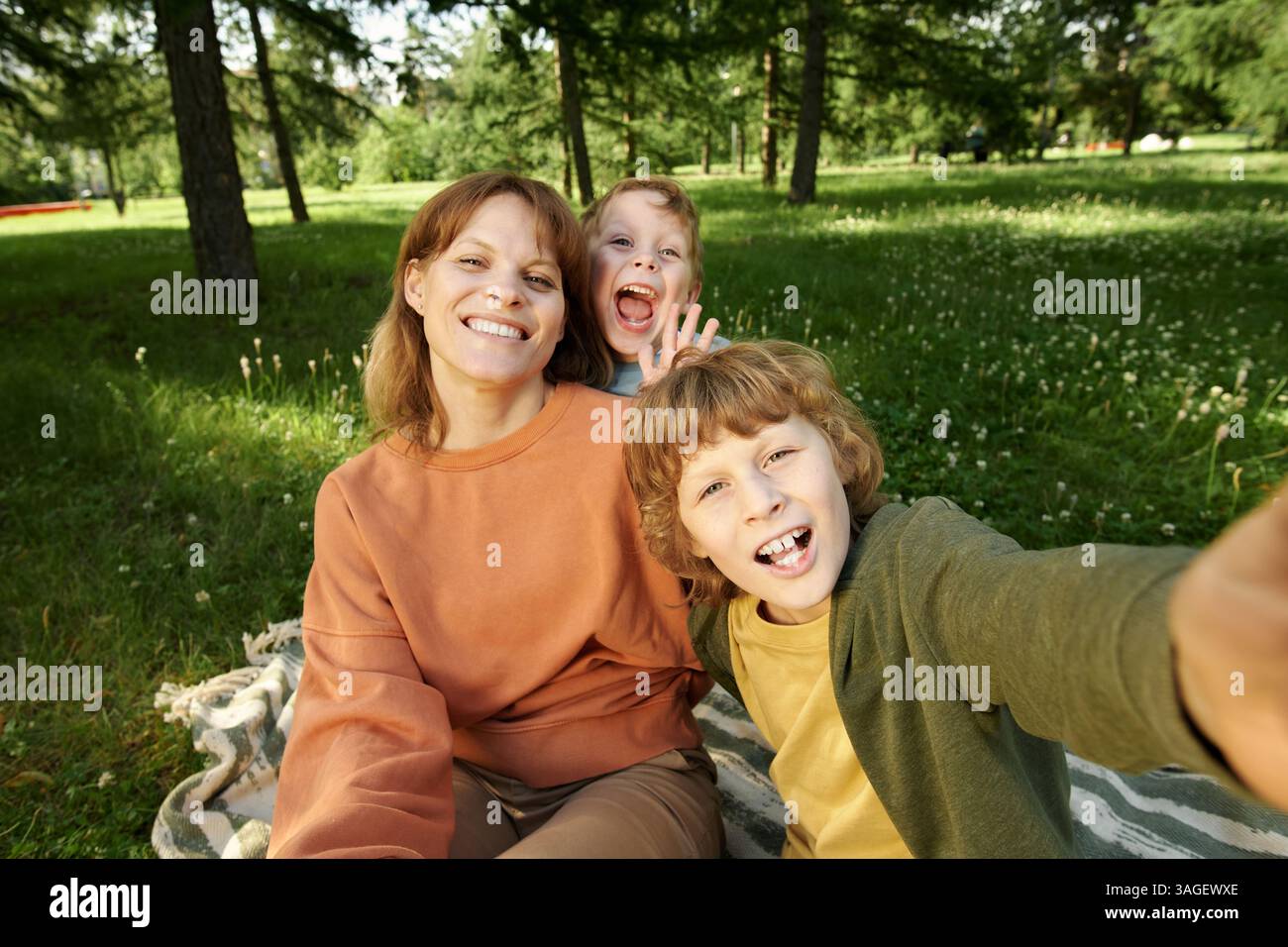 POV Happy Mother et Two Boys prenant Selfie photo sur couverture dans le parc Banque D'Images