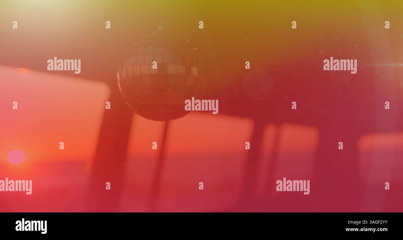 Image de boule de miroir se déplaçant dans le vent avec une teinte jaune à rouge avec coucher de soleil en arrière-plan Banque D'Images