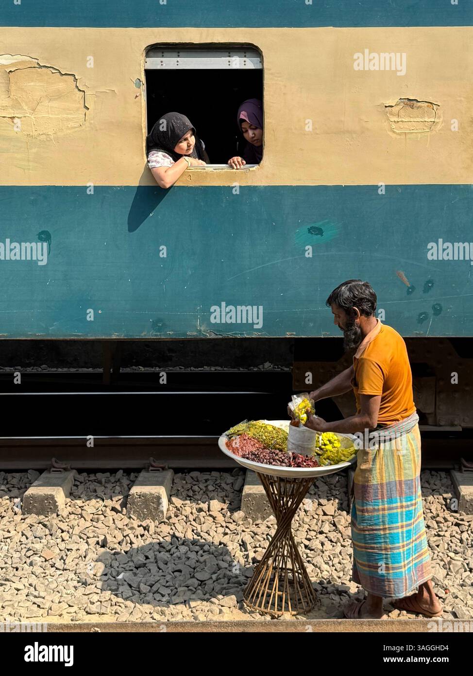Vendeur de rue vendant des collations aux passagers du train, gare de Tongi à côté de Dhaka Bangladesh Banque D'Images