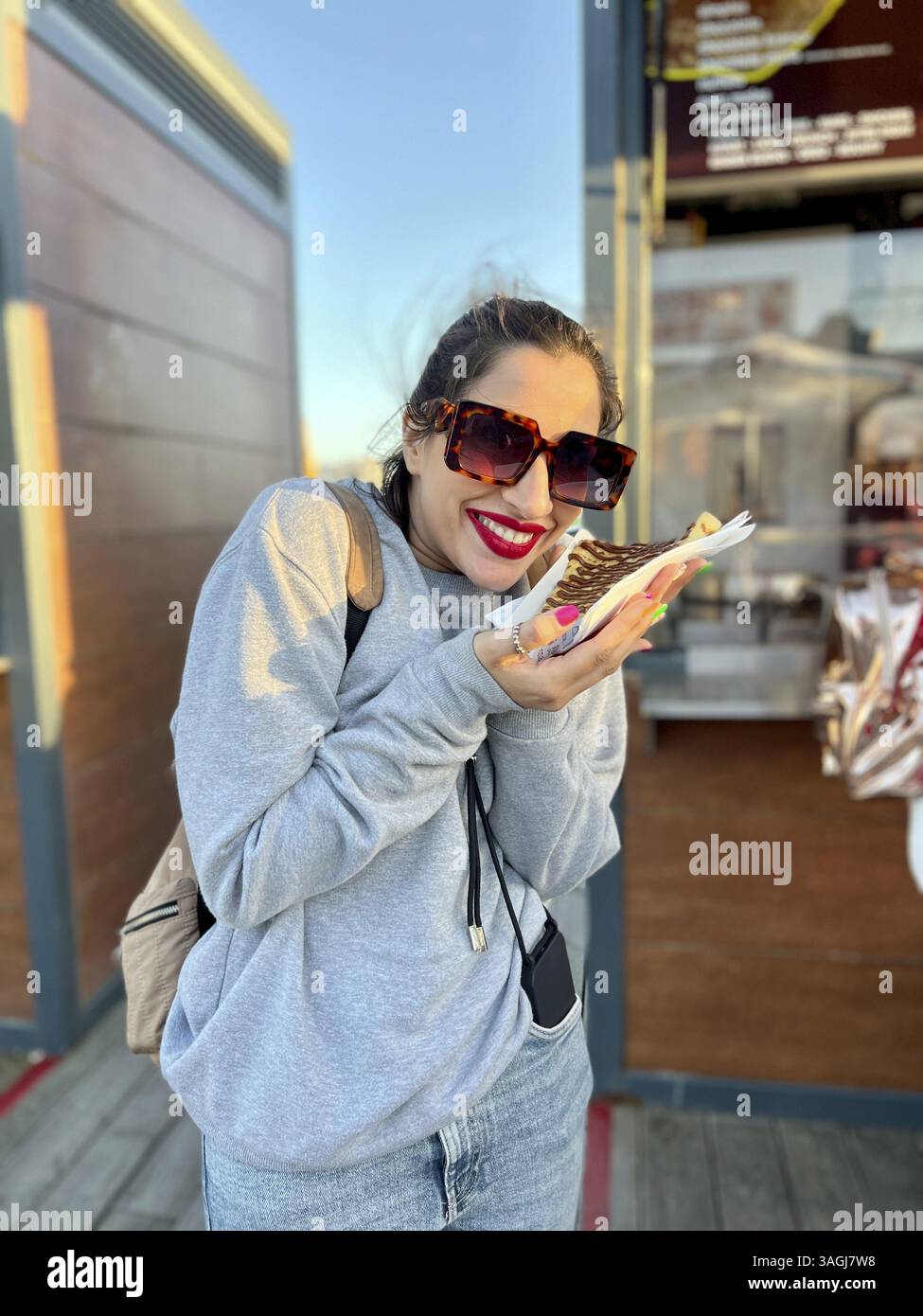 Fille touriste mangeant de la crêpe française dans la rue. Gros plan d'une femme mangeant des crêpes avec du nutella en descendant la rue Banque D'Images