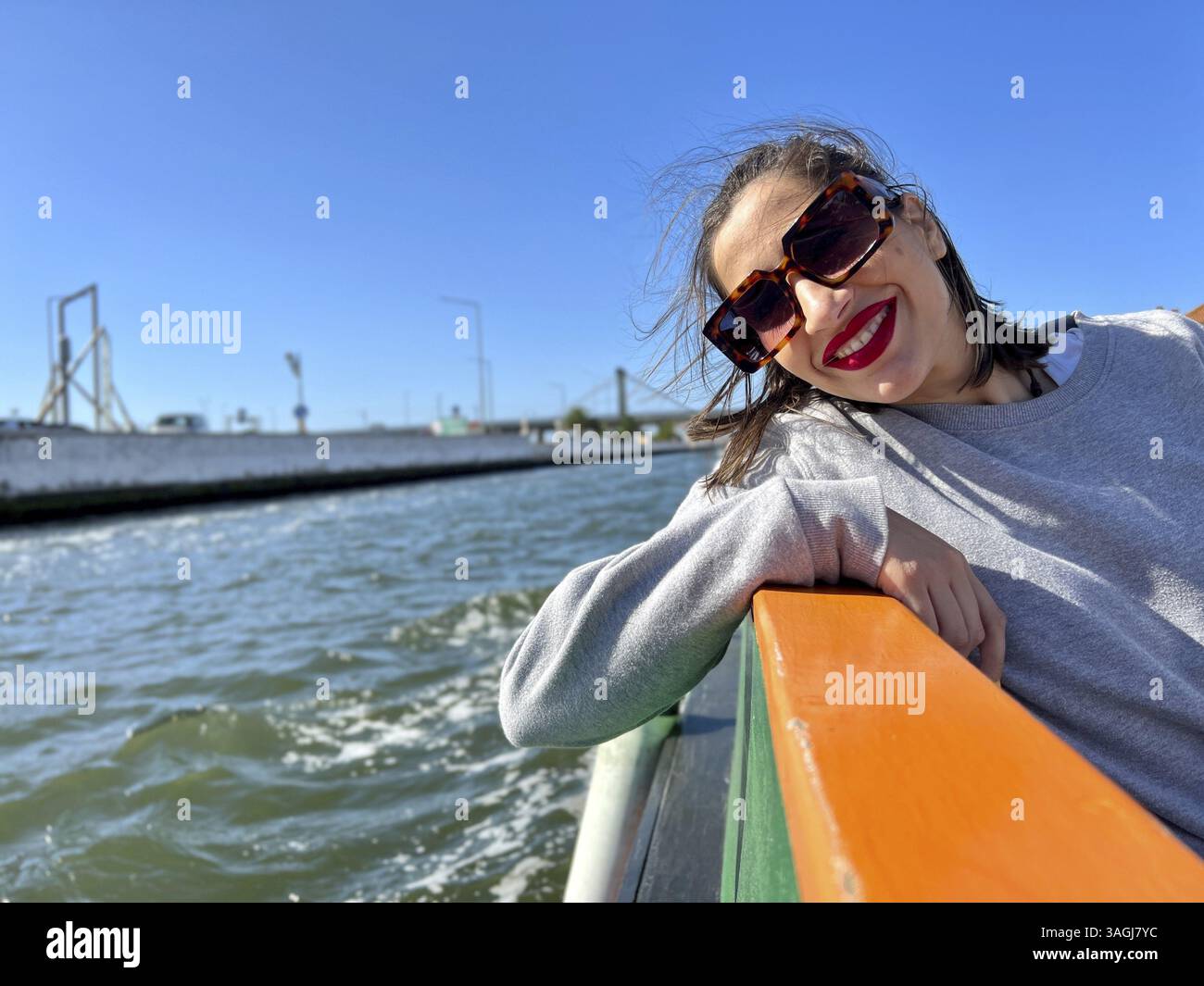 Portrait d'une fille heureuse en lunettes de soleil prenant une promenade en bateau sur la rivière Banque D'Images